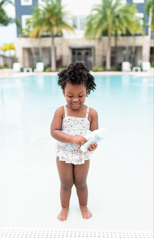 young girl in pool with babo botanicals sun care products