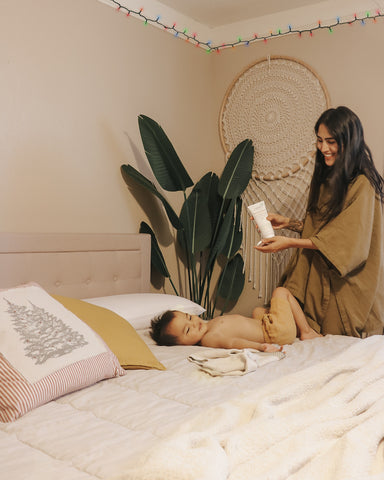 mom on bedtime toddler schedule by applying lotion after bath