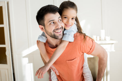 Dad giving child piggy back ride 