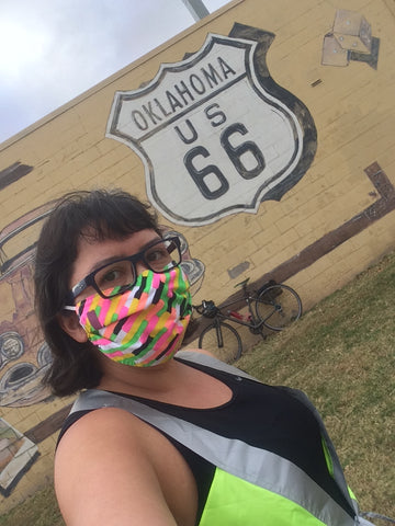Christina Watanabe selfie in front of Route 66 mural wearing a vespert reflective vest