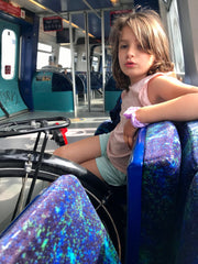 girls sits next to a bicycle on a train car dedicated to bicycles in Copenhagen Denmark