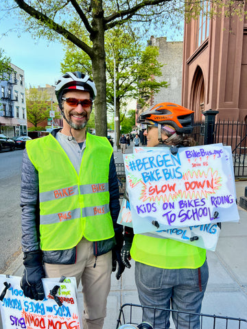 Adult leaders of Brooklyn's Bergen Bike bus wear hi vis reflective vests and signs to keep kids biking to school safe 