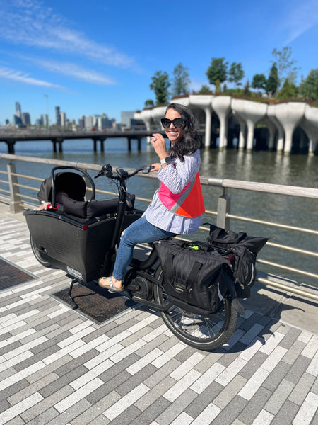 @cargobikemomma wear a Vespert Eco Color block hi vis reflective safety vest on urban arrow cargo bike in NYC by water