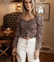 Model wears the Lauren Floral Top with white denim and a brown bucket bag. Top has sweetheart neckline, cinched sleeves, and cropped length.