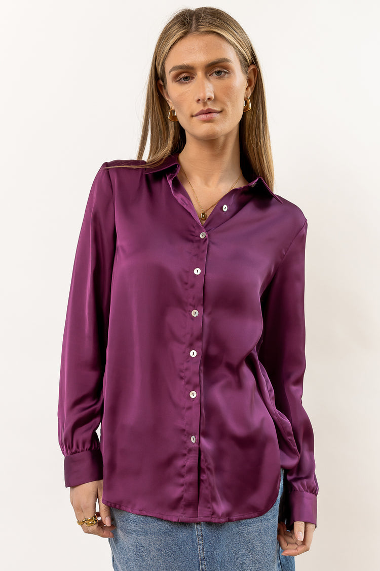 long sleeve satin purple button down paired with medium wash denim skirt