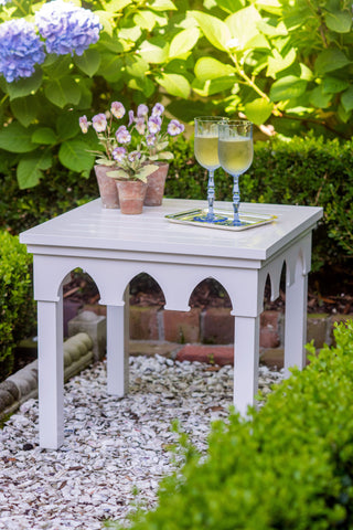 White outdoor table with drinks.