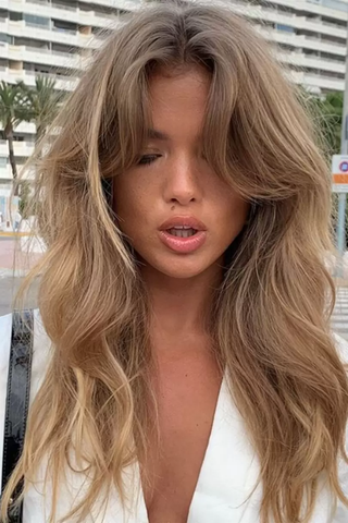 woman with curtain bangs and long wavy hair