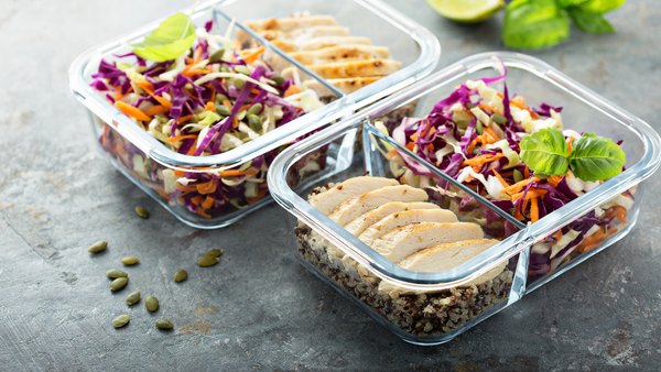 Batch cooking can be helpful. Image shows cooked chicken, quinoa, and coleslaw in two containers for future meals.