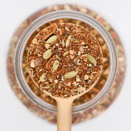 All Chai'd Up Loose Leaf Tea Scooped in spoon. Made with rooibos leaves, ginger, cinnamon, cardamon, fennel seeds and cloves.