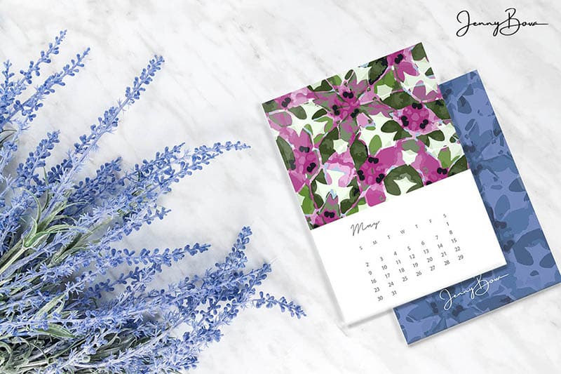 Image of Jenny Bova's 2021 Calendar with the month of May showing. Calendar is in a stack on a marble countertop. There is a fresh lavender bouquet on the left. 