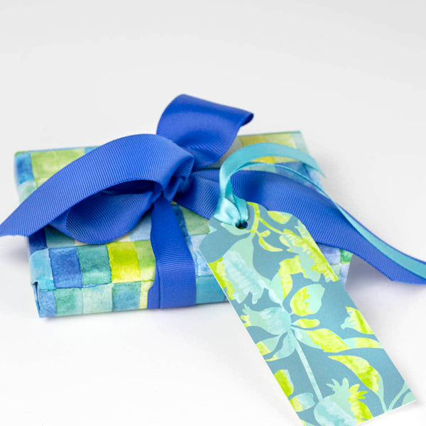 blue green watercolor gift wrap on a small box with a blue ribbon and a coordinating gift tag