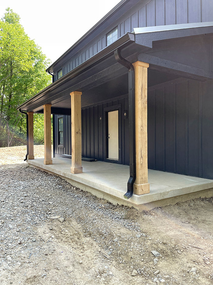 Exterior of a home with Deep Ocean Hardie board and baton, ruff hewn wood posts, and a concrete entry porch.
