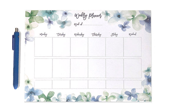 Weekly planner page on a white background with a blue pen next to it. The planner page is outlined with blue and green watercolor florals and there are spots for morning, afternoon, and evening for each day of the week.