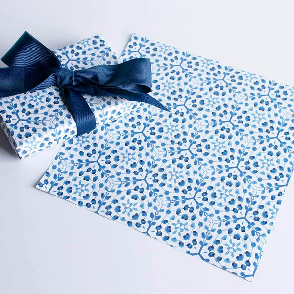 classic blue and white watercolor vine patterned gift wrap shown on a box with a blue ribbon and flat