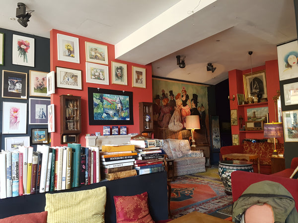 Cafe with many paintings on the wall and books around