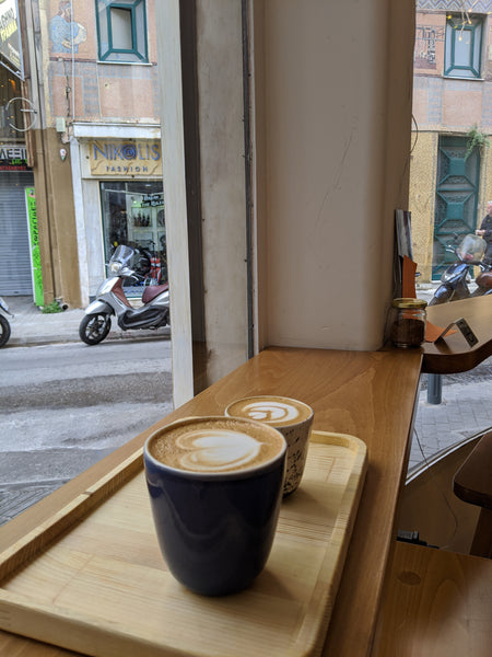 Two coffees on a bar at a window