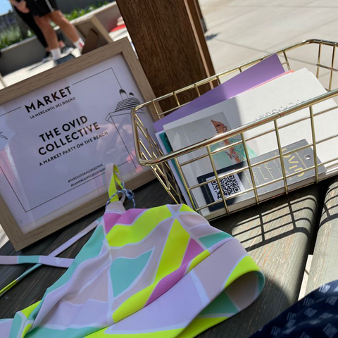 A close up of a table with a frame, wire basket, and neon swimsuit laying on top.