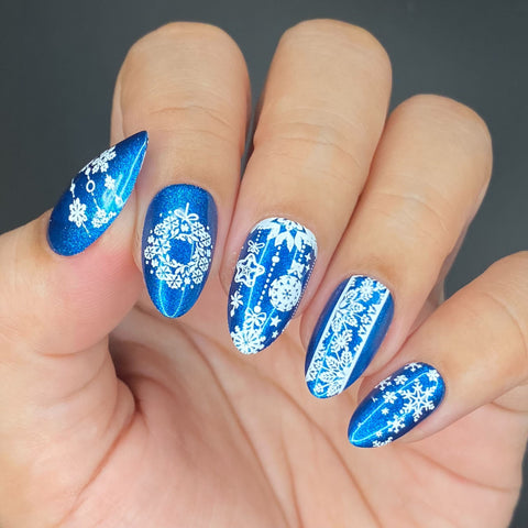 Blue metallic manicure with white snowflake designs