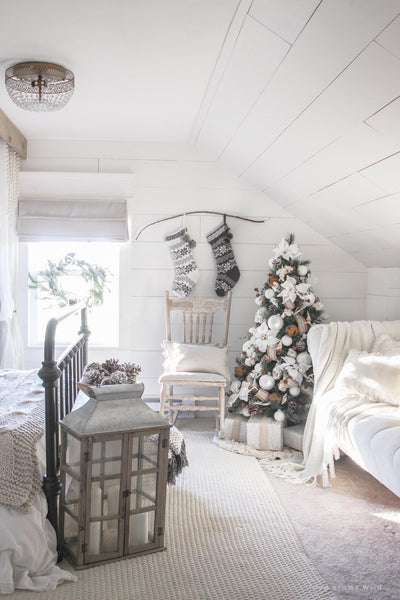 a cozy well lit bedroom with white decor and a christmas tree holly jesus