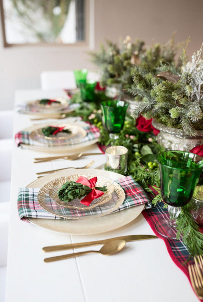 a dining table set with green and red Christmas decor pine tree Christmas eve