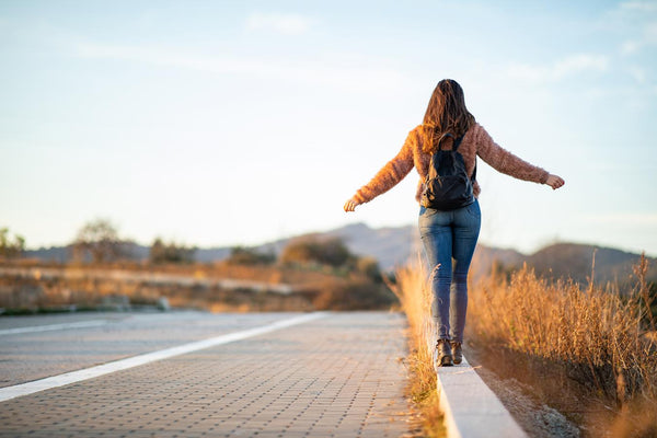 girl walking while balancing on a curb blog post team bonding gratitude meditation find gratitude prompts