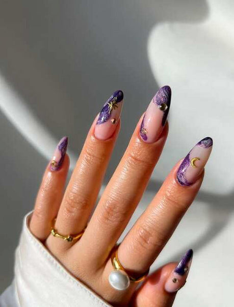 girls hand with purple and gold nail design obsessed working love features
