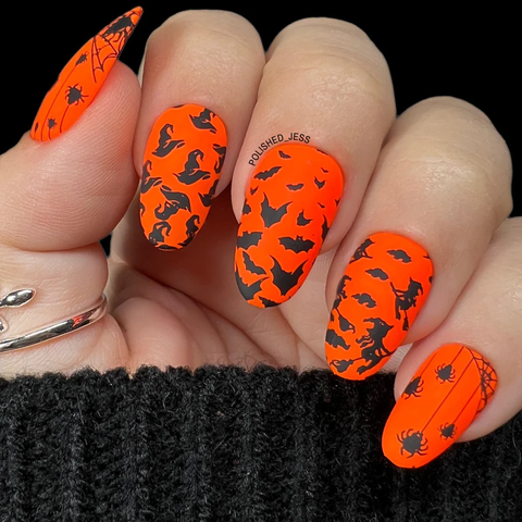Orange and black halloween manicure with a gradient bat design