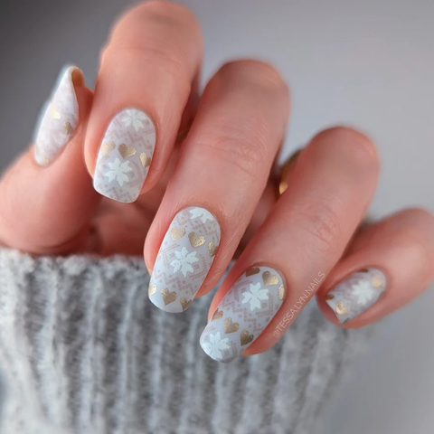 A white and gray neutral manicure with knit christmas sweater designs.