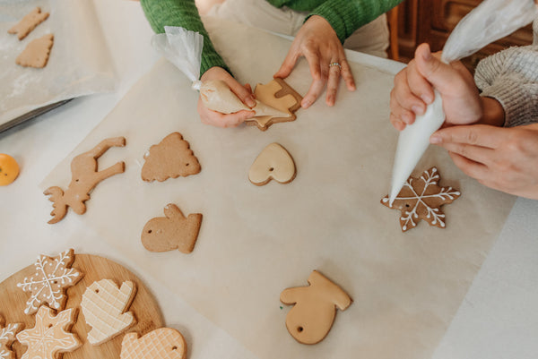 people icing gingerbread cookies for the holidays