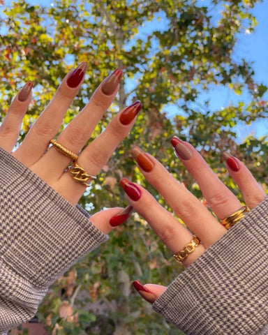 admiring a new manicure towards the sky with trees in the background