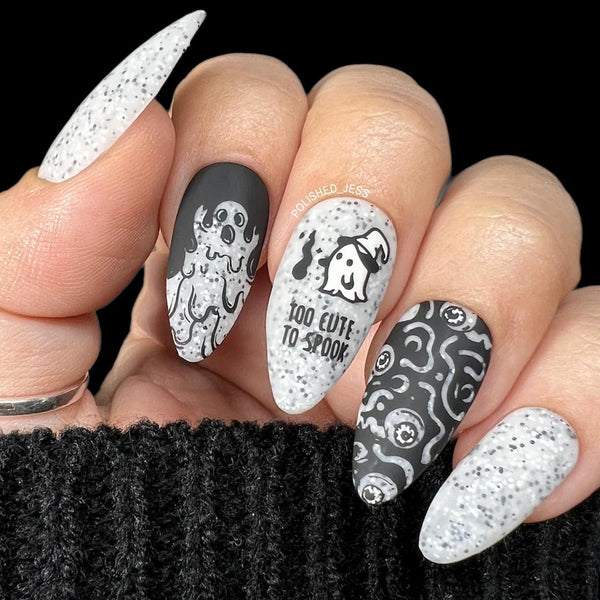 someone showing their nails with grayscaled and decorated nail art stiletto shapes halloween nails halloween nails