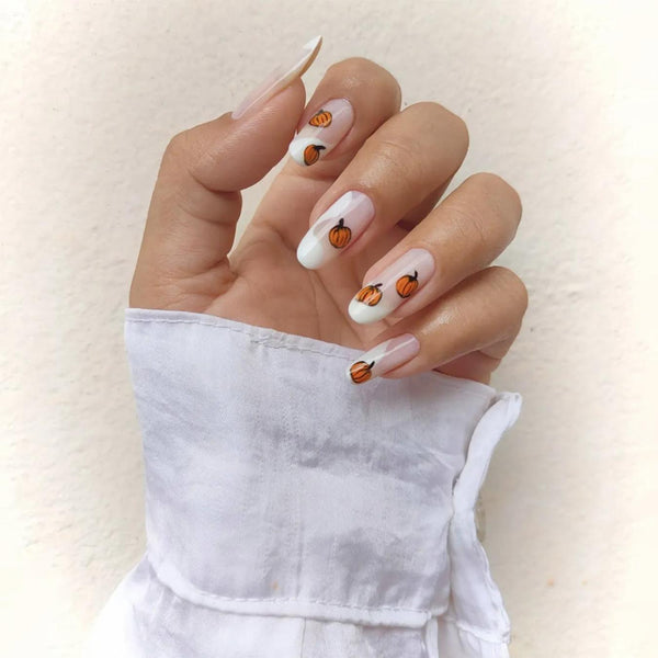someone's hand wearing a white shirt with cute nail art pumpkin tips matte finish pumpkin tip pumpkin pie hope ghosts image stands lattes play pumpkins pumpkin nails pumpkin nails pumpkins pumpkin nails