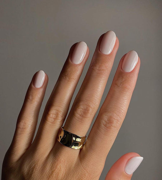 someone s hand with neutral nail polish fall nail colors for pale skin tones yellow undertones darker shades yellow undertones dark yellow nails nail