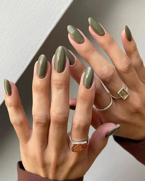 someone's hands with green nail polish steady hand manicure