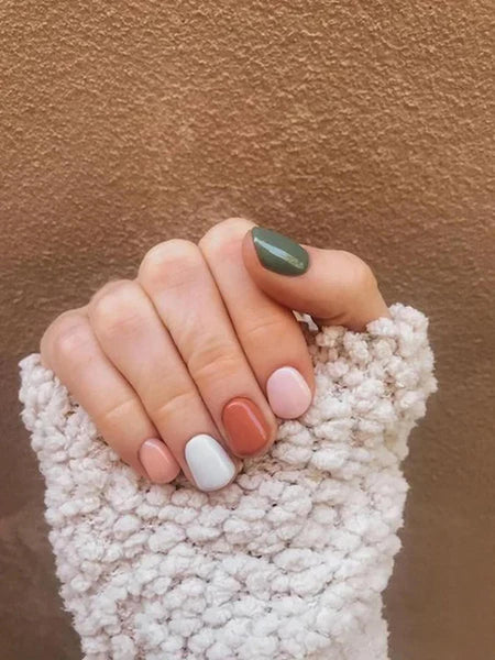 someone's nails with various earthy colored polish fall colors