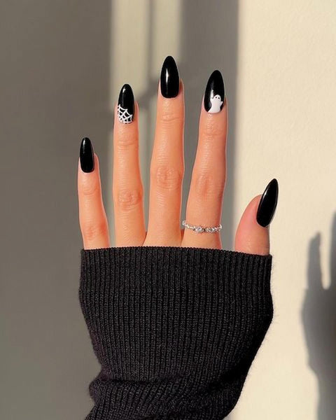 someones hand with black and white nail art black nails bright green gold polish halloween nails halloween nails nails