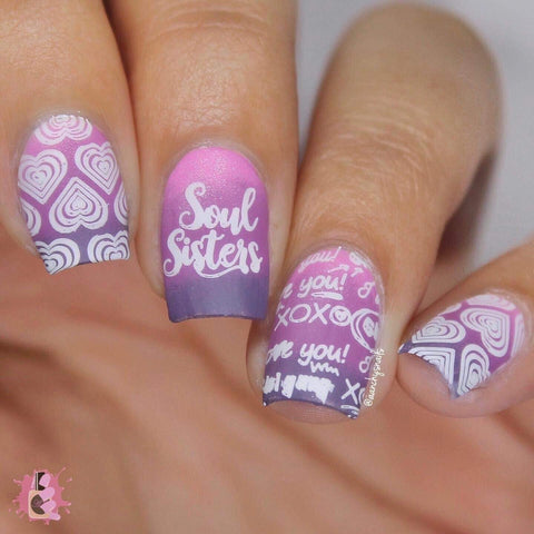 A manicured hand in purple and white with a word and heart design by Maniology.