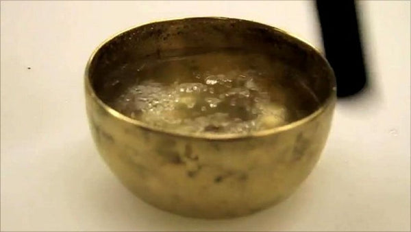 tiny singing bowl filled with water close up view