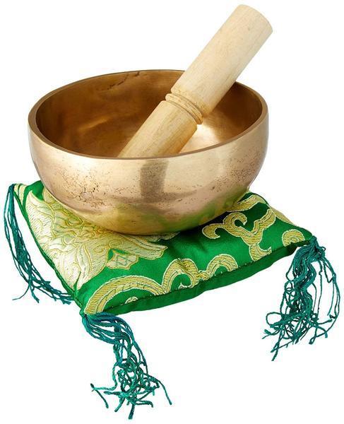 plain singing bowl with mallet inside placed on a green square pillow with tassles
