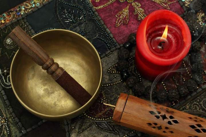 wooden mallet with suede cover placed inside a singing bowl