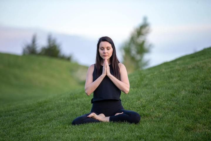 women meditating on a grassy field