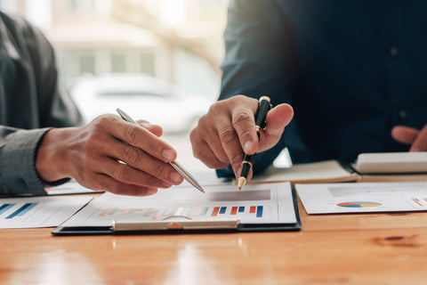 Two people sitting down with a financial plan at a desk