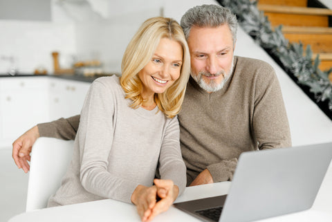 Middle aged man and woman looking at laptop