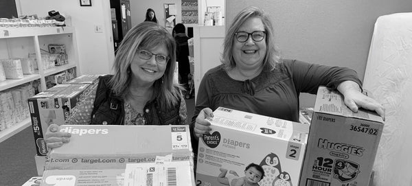 Two women holding baby diapers