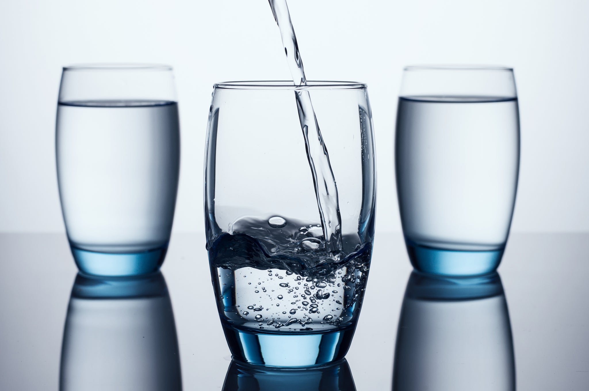 Glass of water on gray background.