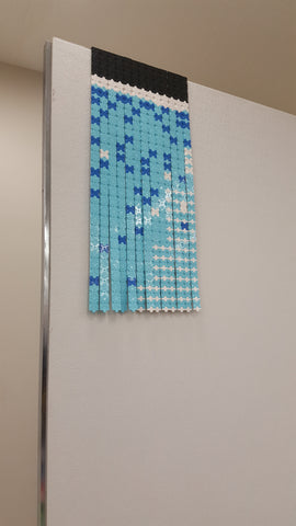 Each strip is hung in order on a large display wall