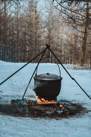 Ein Dutch Oven am Lagerfeuer hängend im Winter 