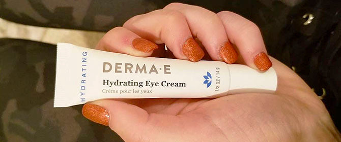 Person holding the hydrating eye cream by Derma E