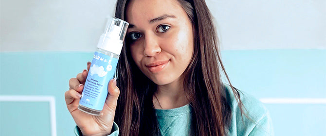 Woman holding volumizing hair spray by Derma E