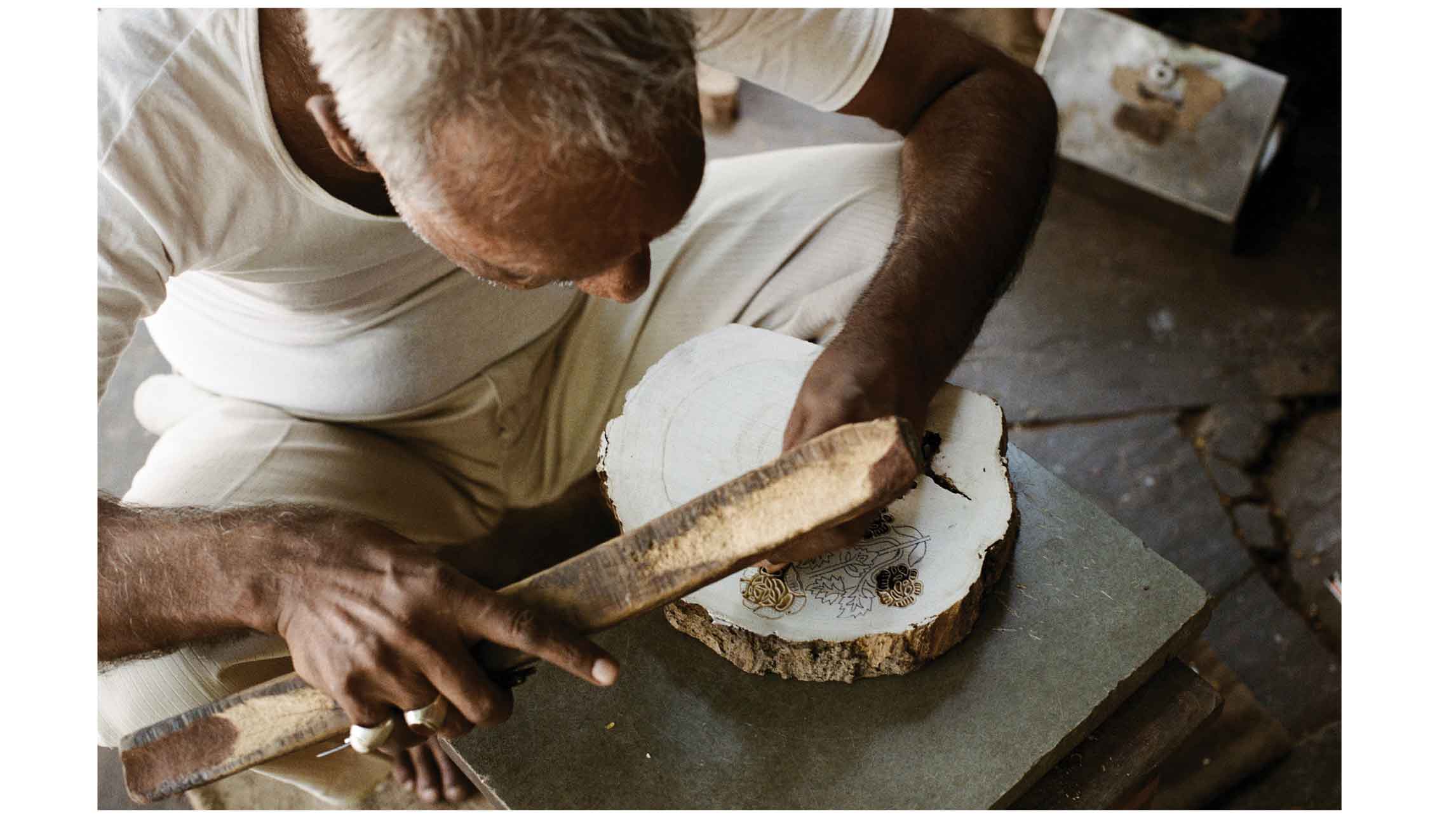 Man hand carving wooden block for block printing